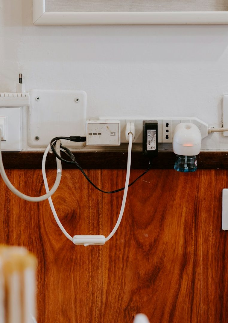 Link zur Rubrik Nützliches Verschiedene Kabel und Steckdosen an einer Wand mit Holzvertäfelung.